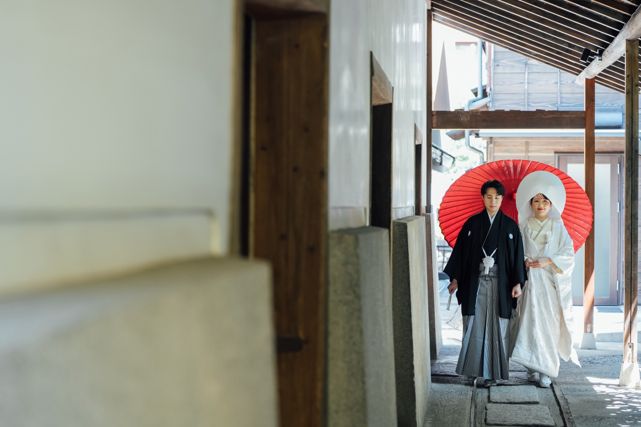 三河屋本店の俥夫演出で新郎新婦を赤の大番傘でお供する様子