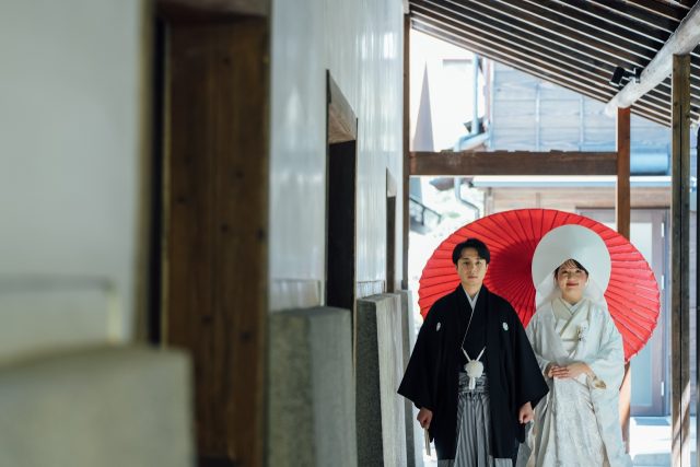 三河屋本店の俥夫演出で新郎新婦を赤の大番傘でお供する様子
