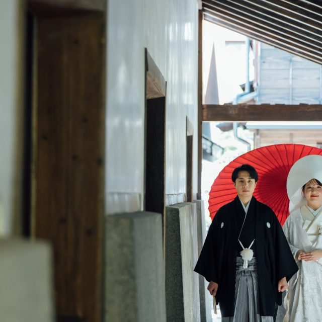 三河屋本店の俥夫演出で新郎新婦を赤の大番傘でお供する様子