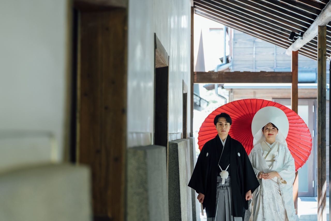 三河屋本店の俥夫演出で新郎新婦を赤の大番傘でお供する様子